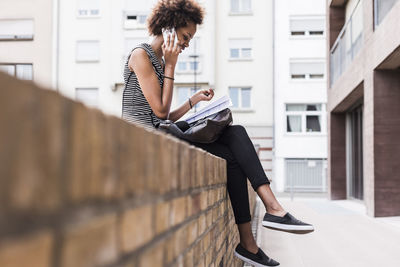 Side view of young woman sitting outdoors