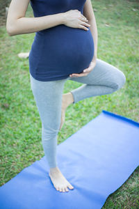 Low section of woman standing on grass