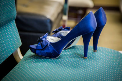 Close-up of blue high heels on chair