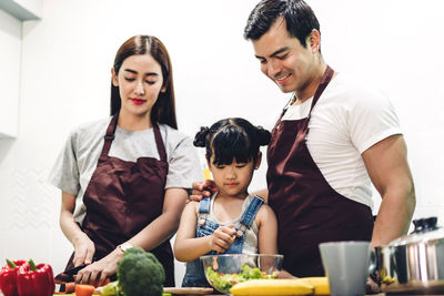 Friends looking away while sitting on cutting board