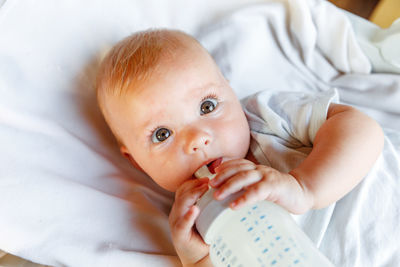 Baby lying on bed at home