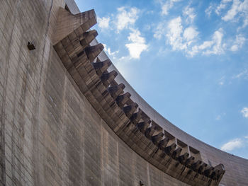 Low angle view of dam against cloudy sky