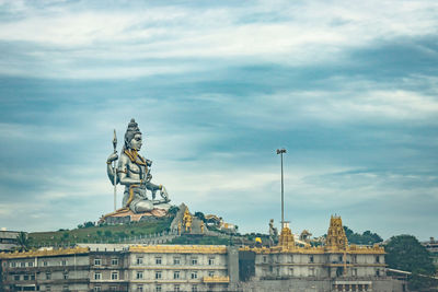 Statue of historic building against cloudy sky