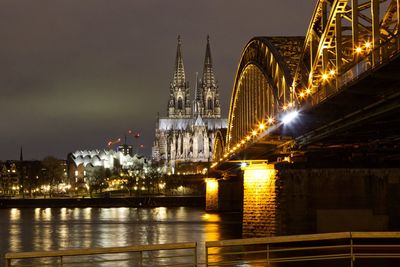 Illuminated bridge and dome over river at night