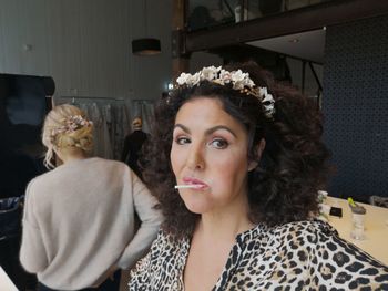 Portrait of mature woman having lollipop at backstage