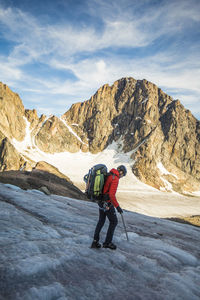 Side view of backpacker crossing a high mountain pass