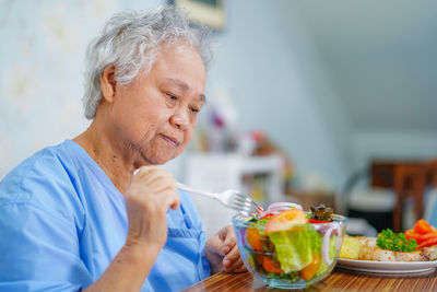 Senior female patient having salad at hospital