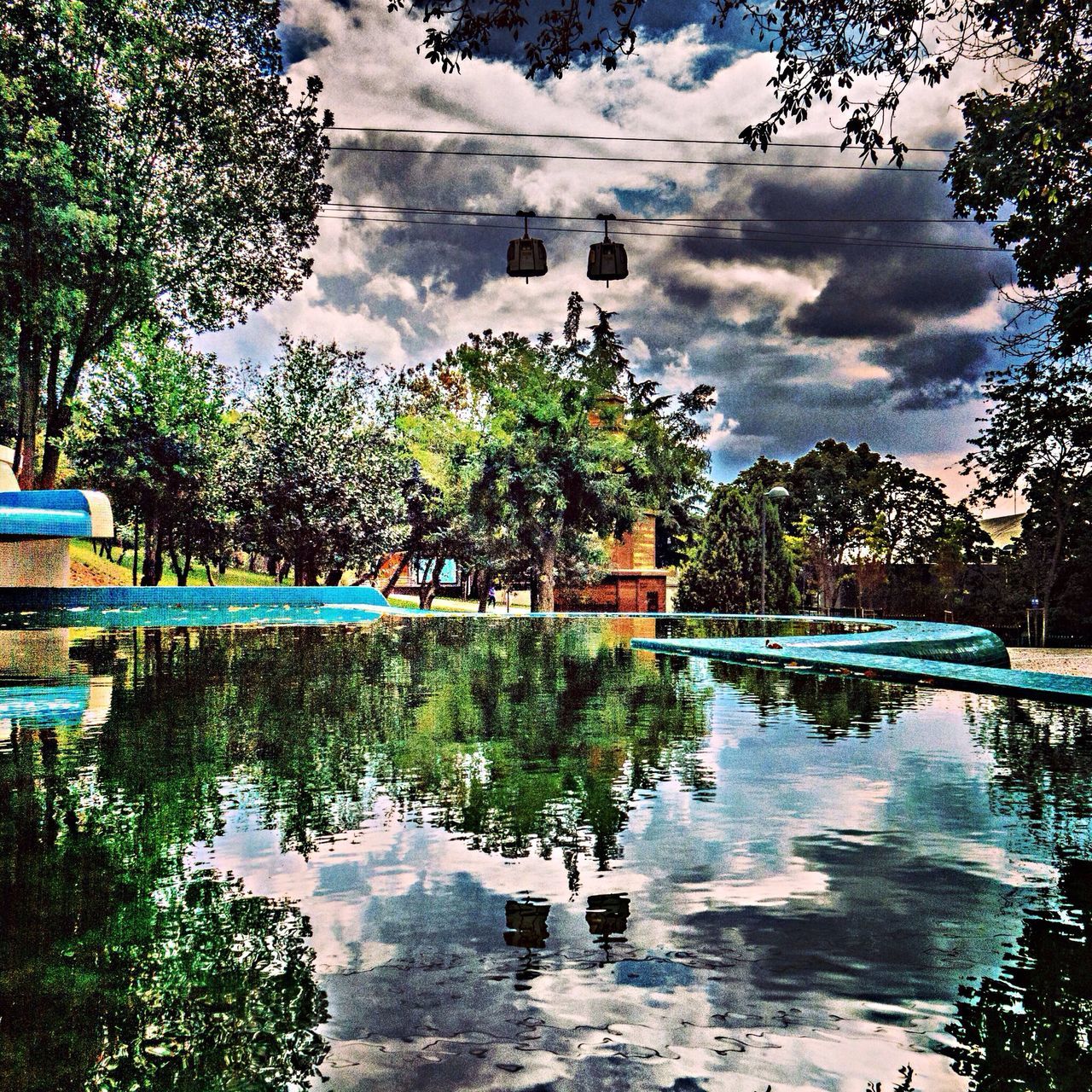 tree, water, sky, reflection, cloud - sky, lake, tranquility, cloud, tranquil scene, palm tree, nature, cloudy, swimming pool, waterfront, scenics, growth, day, beauty in nature, standing water, pond