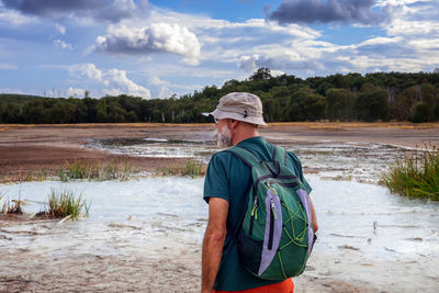 Hiker visits the caldera, a small circular crater with a marsh of sulphurous waters