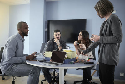 Multi-ethnic engineers at table while working on project in office