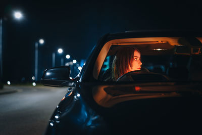 Young woman in car at night