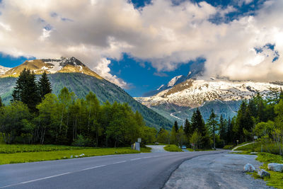 Road leading towards mountains against sky