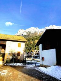 Houses on snowcapped mountain against sky