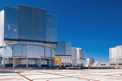 Buildings in city against clear blue sky