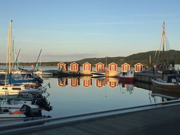 Boats moored at harbor against sky