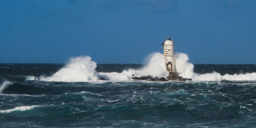 Water splashing in sea against clear sky