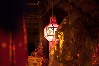 Close-up of illuminated lantern hanging in building at night