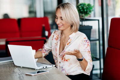 Young woman using phone while sitting on seat