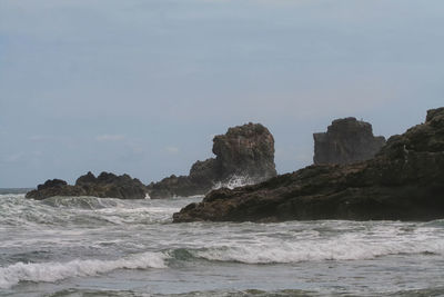 View of calm sea against rocky shore