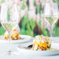 Two crab stack salads served with white wine against a soft focus background.