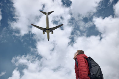 Low angle view of airplane flying against sky