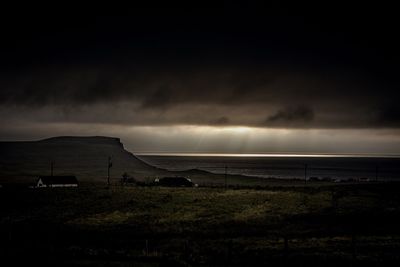 Scenic view of landscape against storm clouds at night