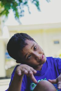 Portrait of boy making face while sitting outdoors