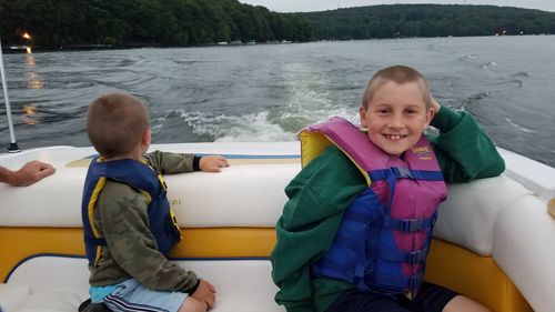 Full length portrait of smiling boy on water