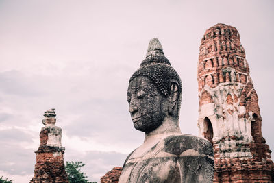 Low angle view of statue of historic building against sky