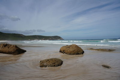 Rocks on beach against sky