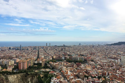 Aerial view of cityscape by sea against sky