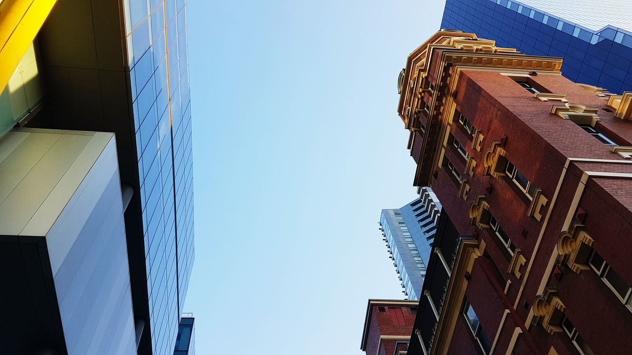 LOW ANGLE VIEW OF BUILDINGS AGAINST BLUE SKY