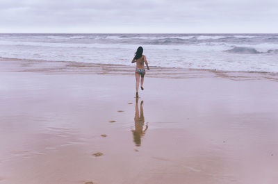 Rear view of man standing on beach