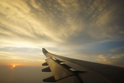 Cropped image of airplane flying over cloudscape