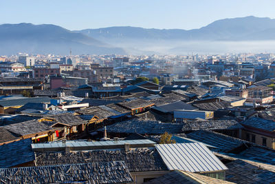 Townscape and mountains against clear blue sky