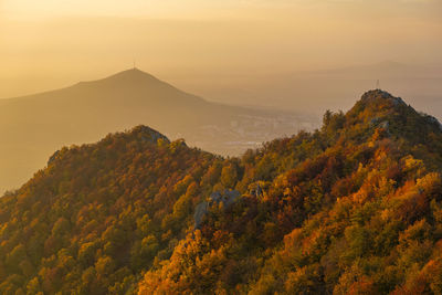 Scenic view of tree mountains against sky during sunset