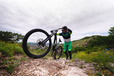 Man pushes a mountain bike up a mountain. adventure travel by bike. freestyle competition, mountain