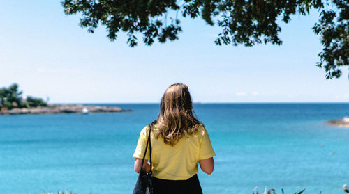 Rear view of woman looking at sea against sky