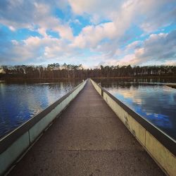 View of swimming pool by lake against sky