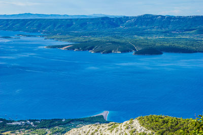 High angle view of sea and mountains against sky