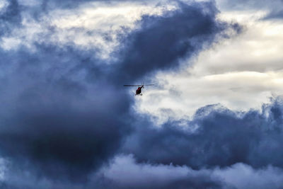 Low angle view of silhouette airplane against sky