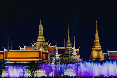 Illuminated temple building against sky at night