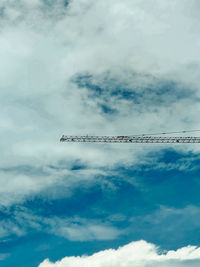 Low angle view of crane against sky