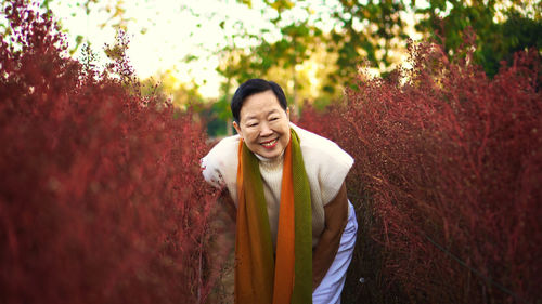 Asian senior woman smile happy in red flower field happy leisure retirement