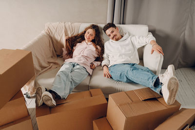 Young woman using digital tablet while sitting on sofa at home