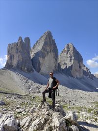 Full length of man on rock in mountains against sky