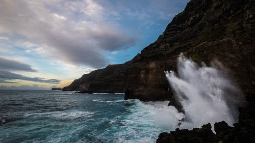 Scenic view of sea and rock formation against sky