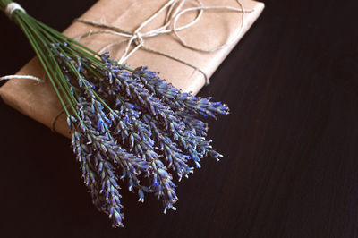 Craft paper gift box with fresh flowers on a black background.