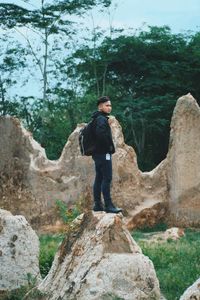 Full length of young man standing on rock