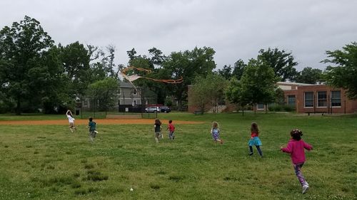 Children playing with kite against sky